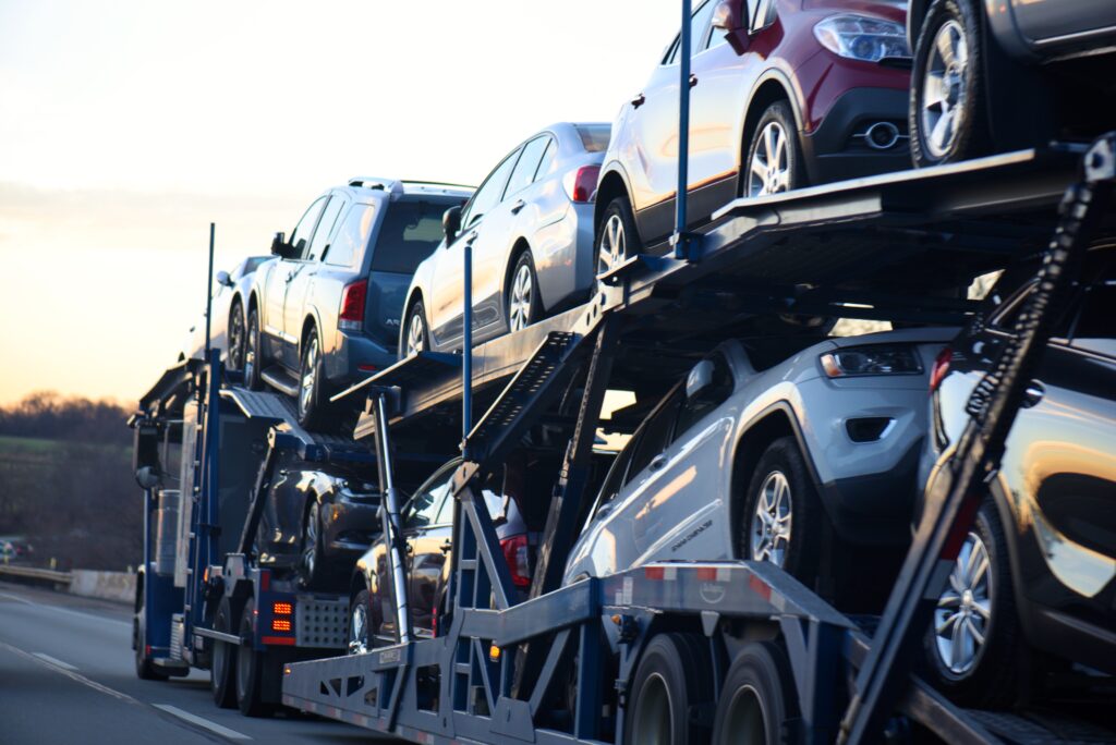About us: Hanamark auto transport truck carrying multiple vehicles on the highway, demonstrating professional vehicle relocation service.