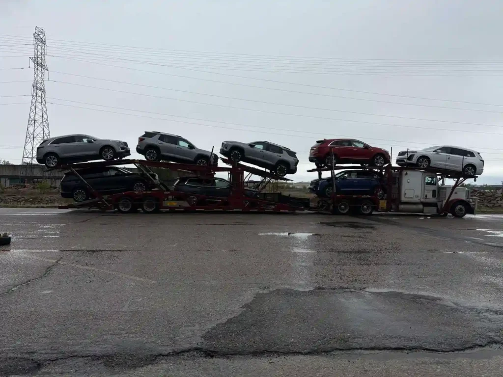 Open car shipping carrier truck loaded with multiple SUVs and crossovers parked during a transit route to Ottawa.